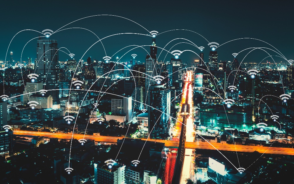 Image of Cityscape at night with Wi-Fi icons connected by lines across the entire city 