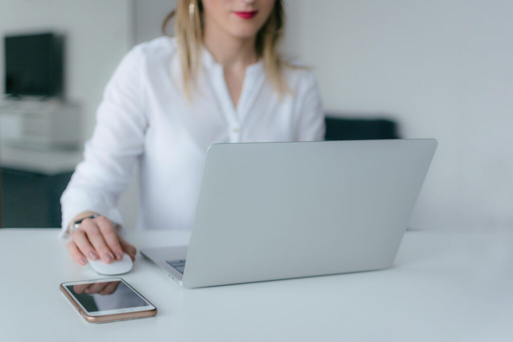 A person using a computer and a phone